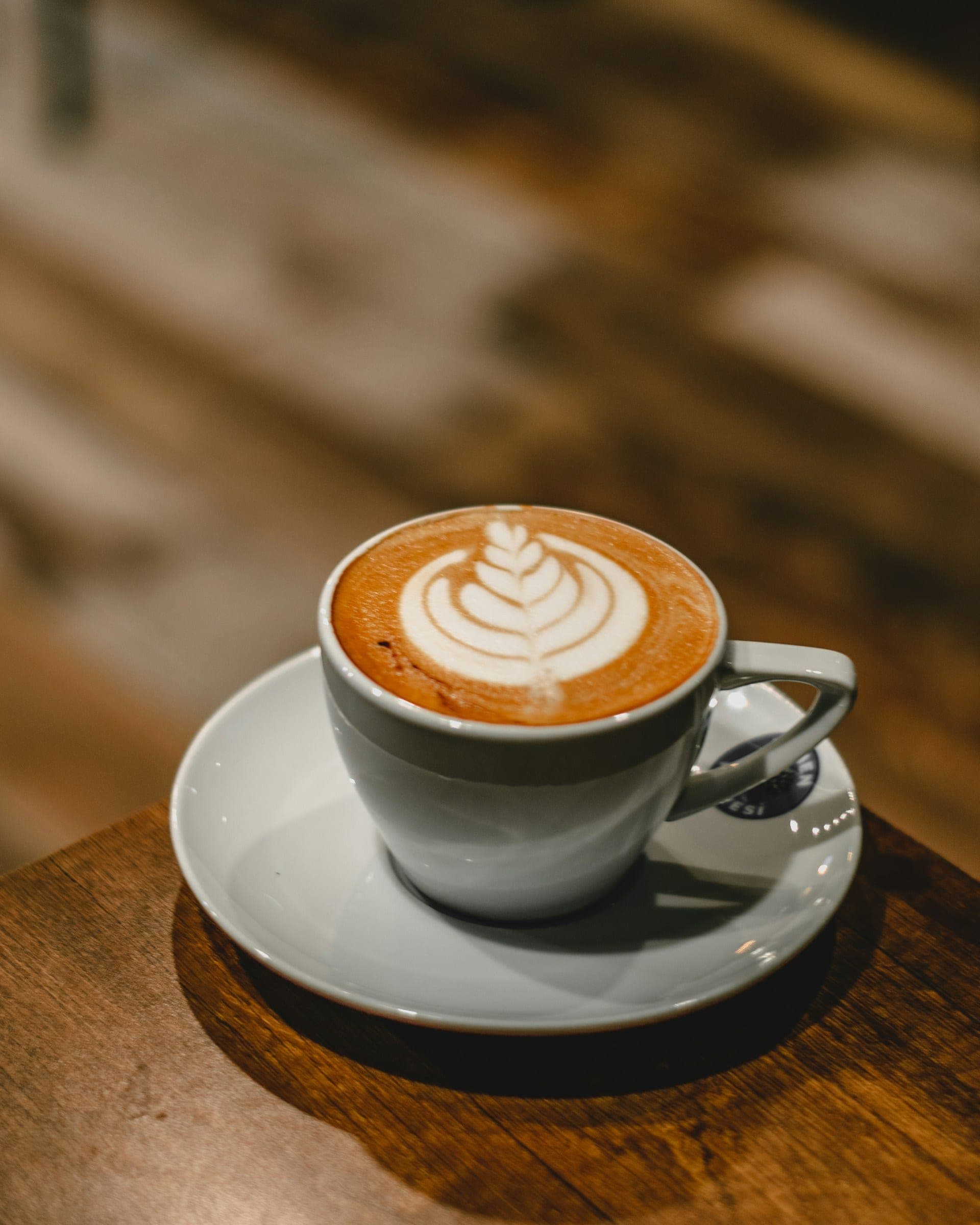 Cappuccino u beloj keramičkoj šolji na tacni