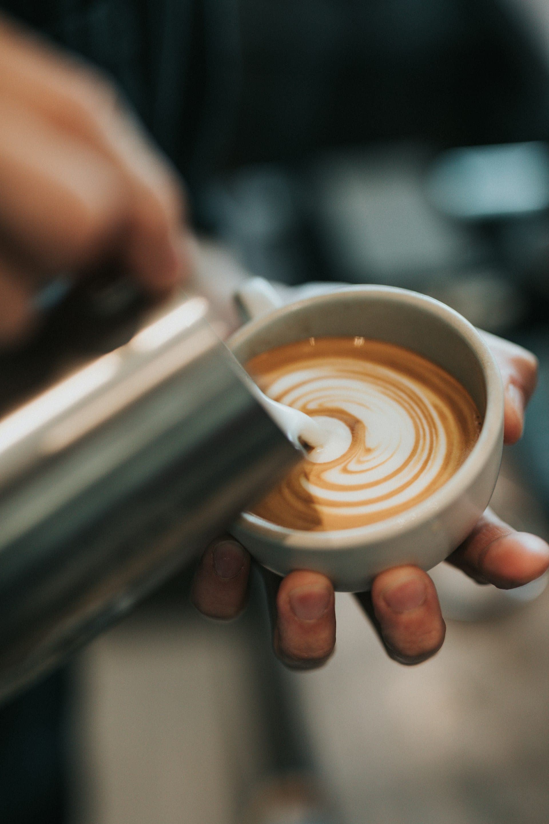 Mleko se uliva u keramičku šolju sa espressom